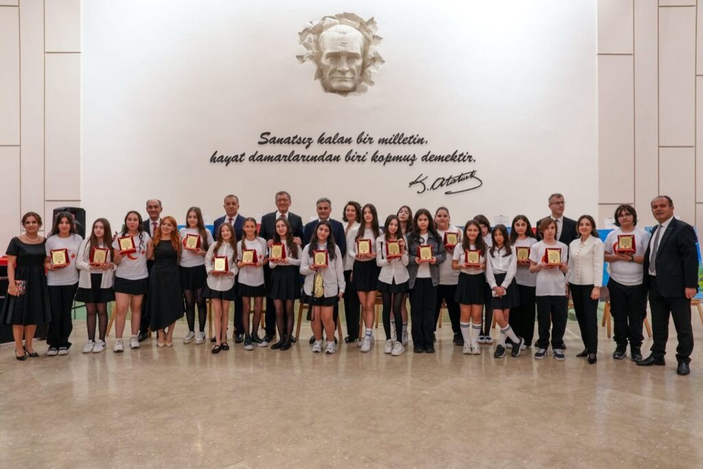 Plaketleriyle Maya Okulları öğrencileri ve öğretmenleri, Atatürk rölyefinin önünde